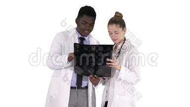 严肃善良的女医生和美国黑人医生在白色背景下研究大脑x光。